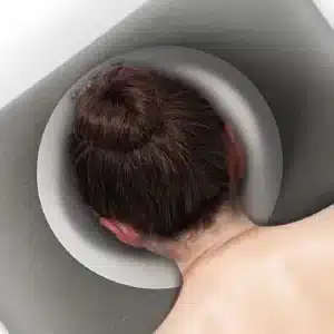 ראש מונח בכרית פנים למיטת טיפולים בצבע אפור